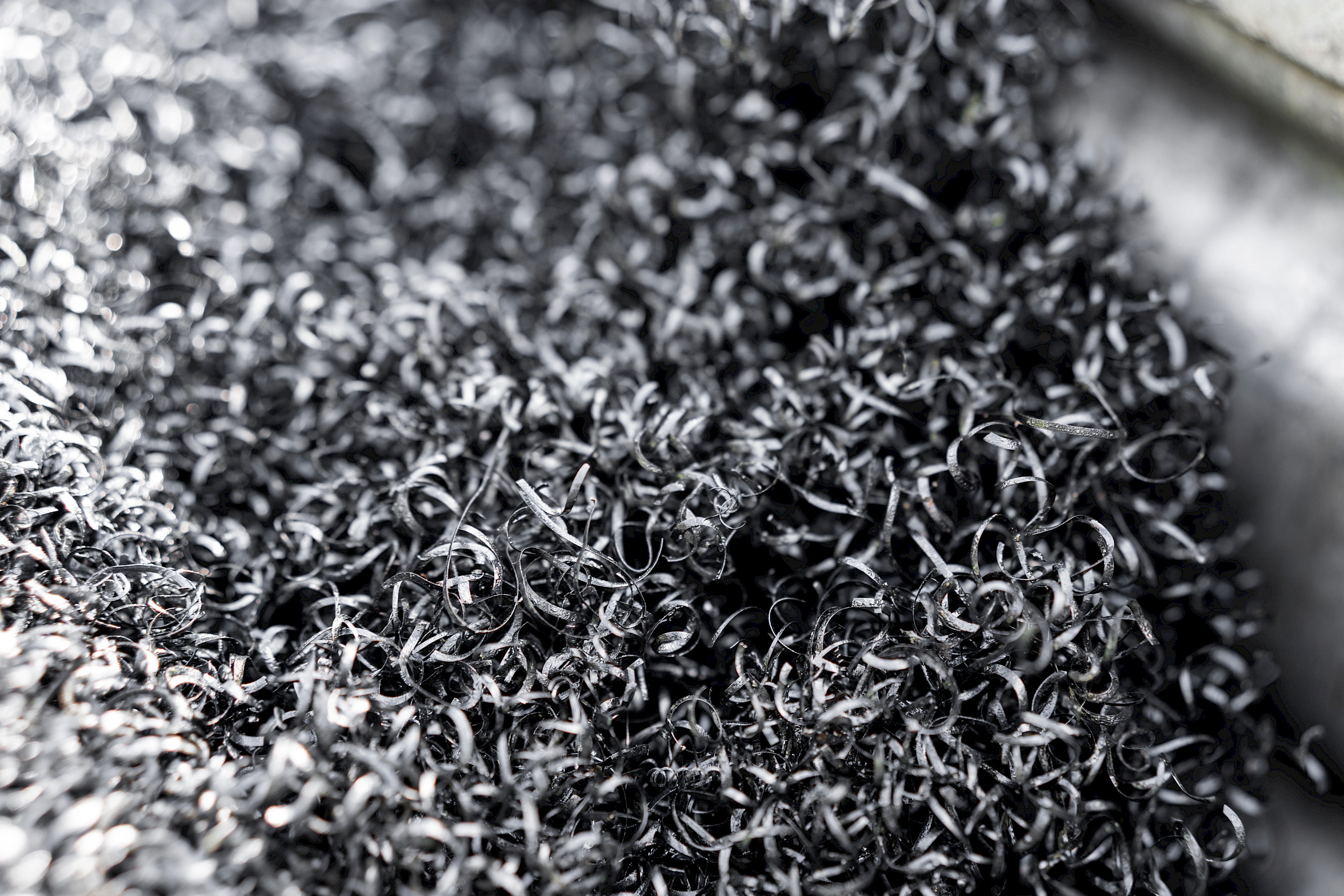 Frische Edelstahlspäne in einem Behälter, die eine spiralförmige Struktur bilden.